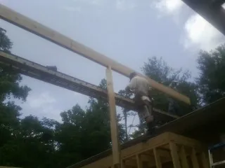 Carpenter setting a ridge beam over a new addition frame — Ice Dam Removal by Roofing Brothers in East Longmeadow