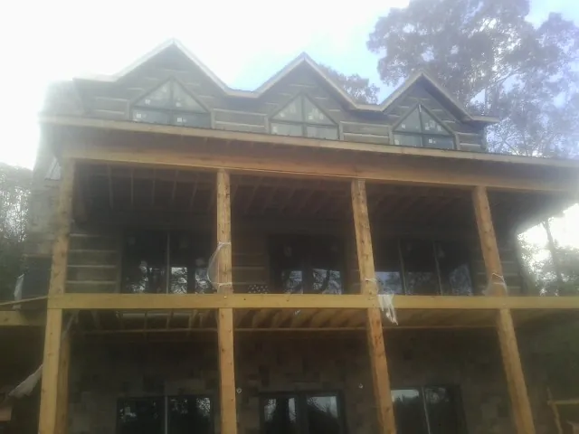 Dormers and porch framing on a large log home under construction — Roof Coating work by our crew in East Longmeadow